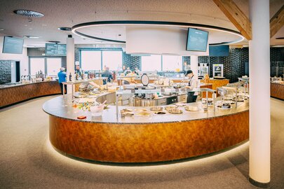 Large round counter in a modern restaurant with staff.