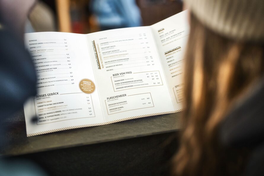 Person looking at the menu at Galzig Restaurant.