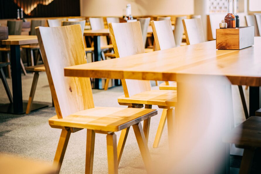 Empty dining area of Galzig restaurant with wooden furniture.