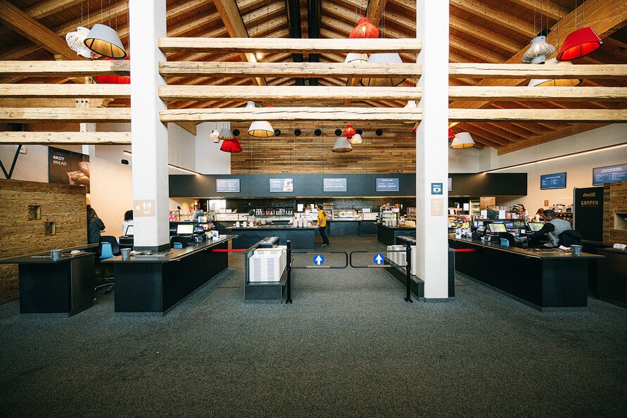 Spacious counter at Gampen Restaurant with modern lights and wooden ceiling.