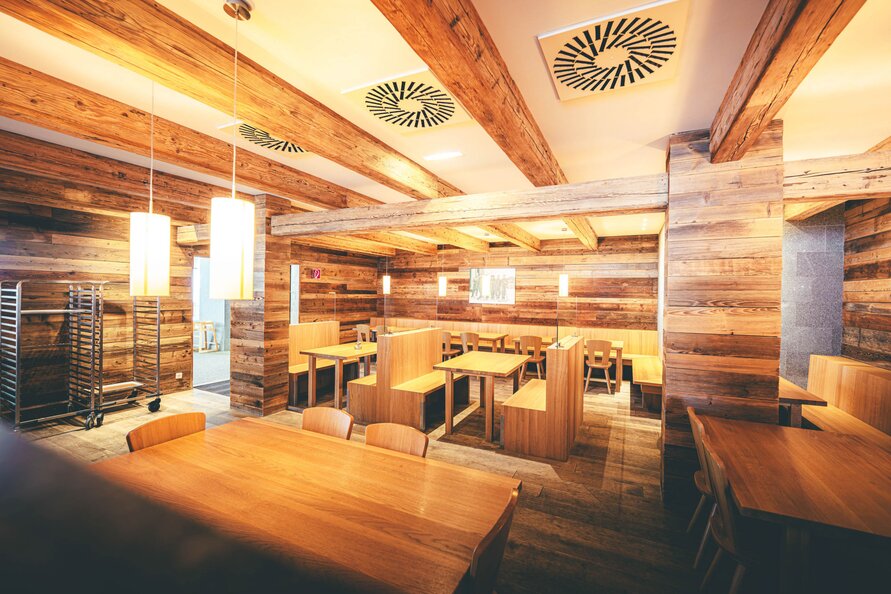 Holzverkleidetes Interieur mit Sitznischen im Rendl Restaurant.