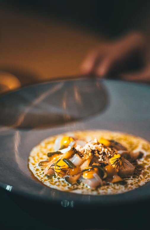 Schön angerichtete Speise auf grauem Teller in der Verwallstube serviert.