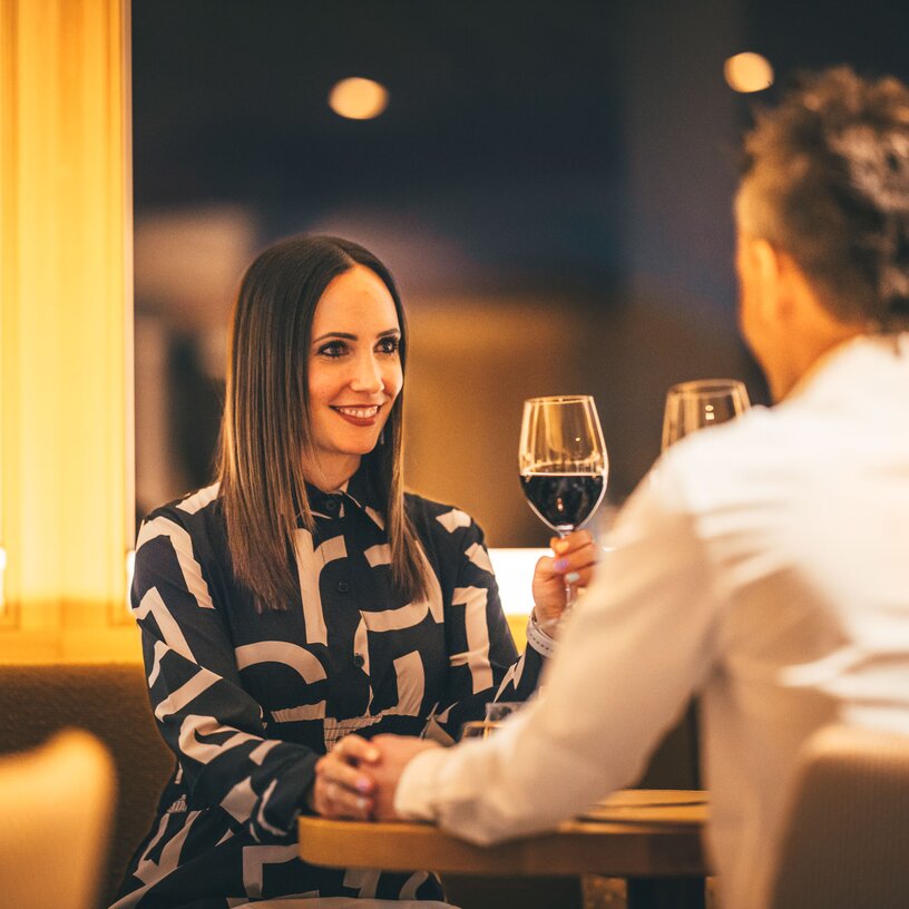 A couple enjoying wine at a romantic dinner.