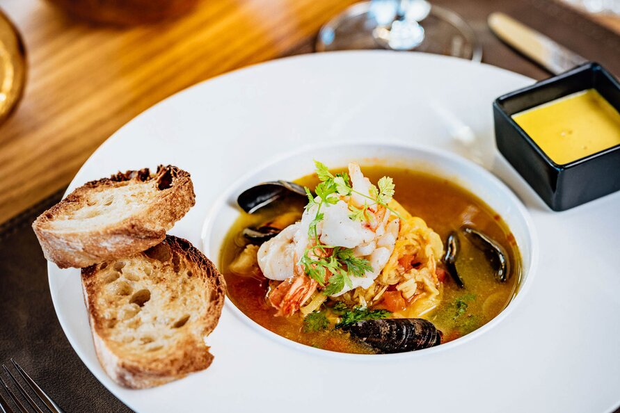 A seafood dish with bread at Verwallstube, accompanied by white wine.