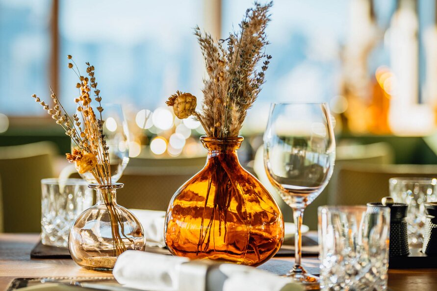  Elegant table setting with dried flowers, glasses, and napkin at Restaurant Verwallstube. 