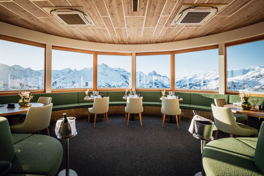 Interior of Verwallstube with a view of snow-covered mountains.