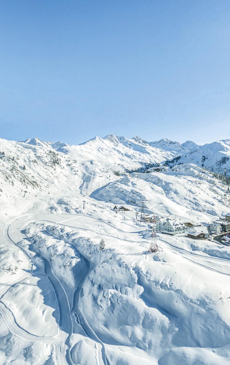 Snow-covered mountains and valley with a small village.