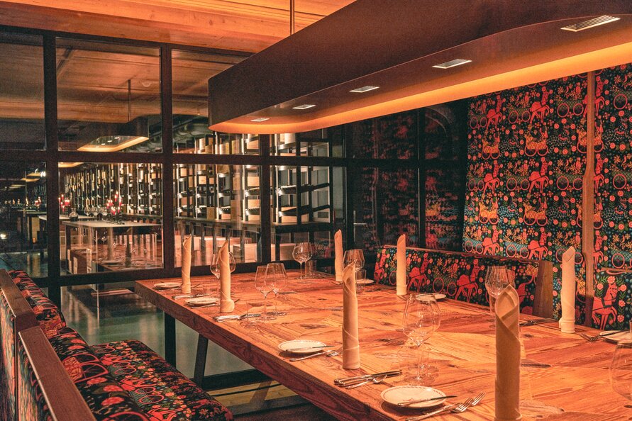 Stylishly decorated dining area with wooden table and colorful bench.