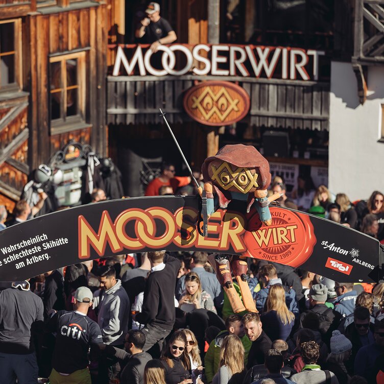 Crowd at MooserWirt, St. Anton, with wooden decor element above the entrance.