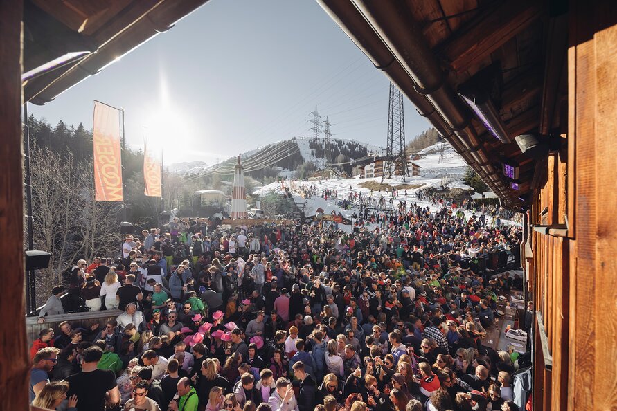 Large crowd enjoying an après-ski party in the snow.