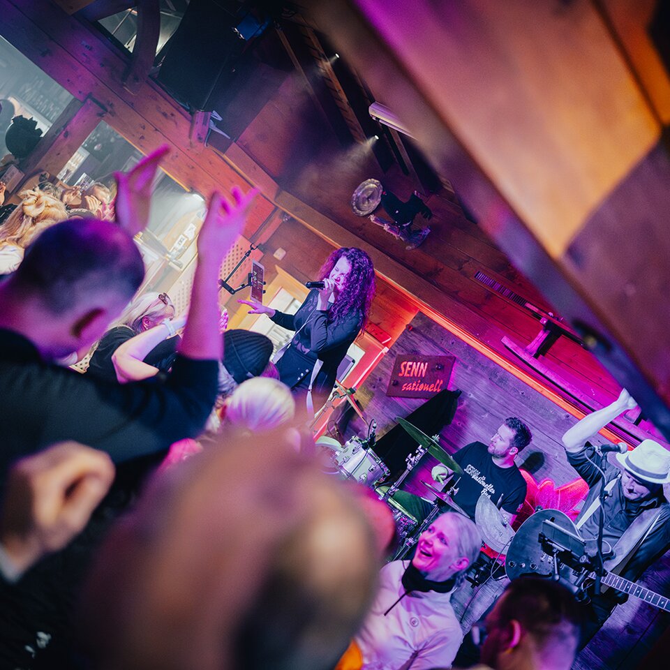 People cheering for a band performing live in a bar.