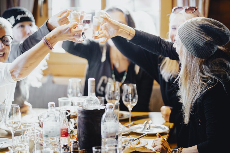 Group of people clinking glasses during a meal.