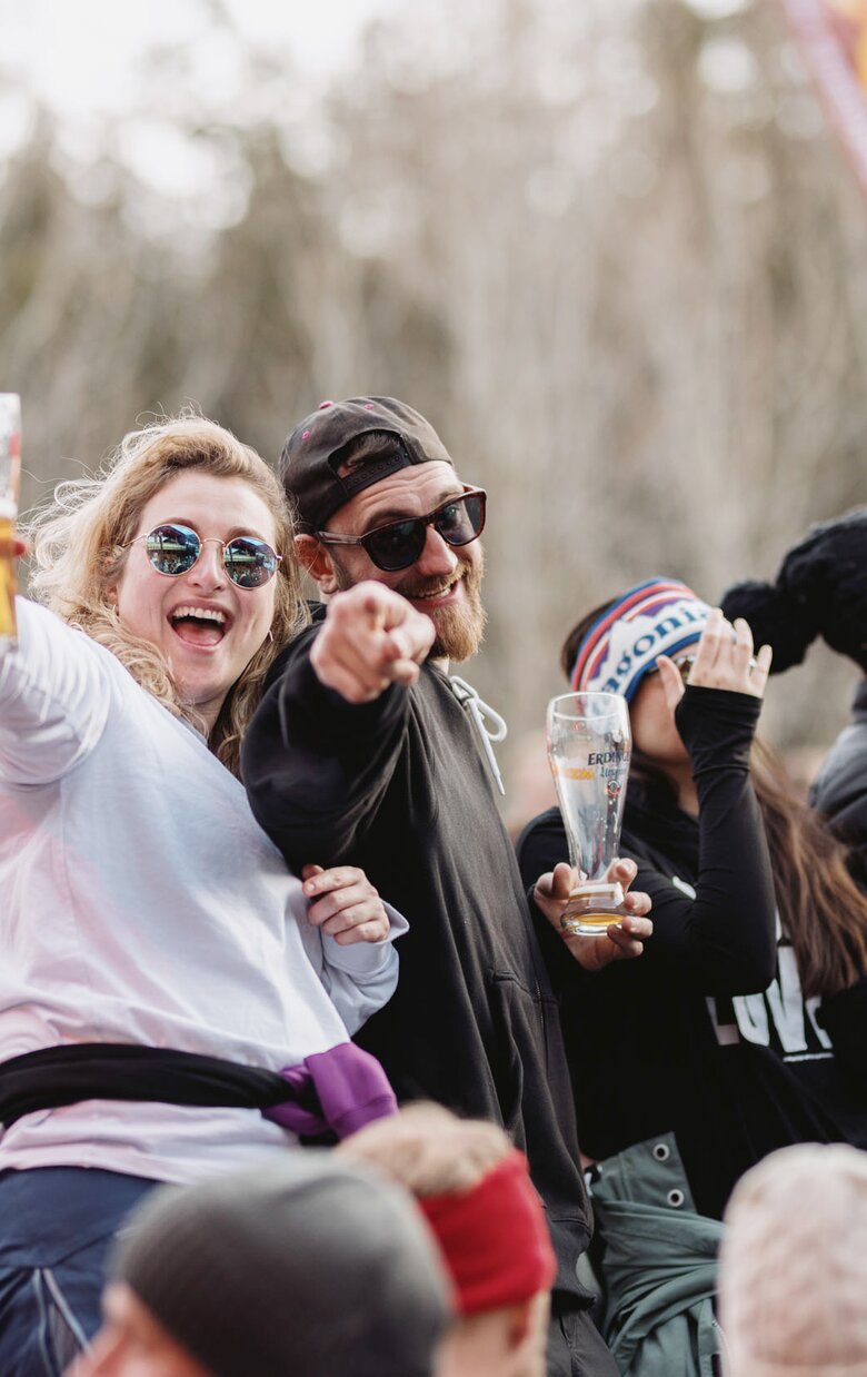 Menschen feiern mit Getränken auf einer Après-Ski-Party.