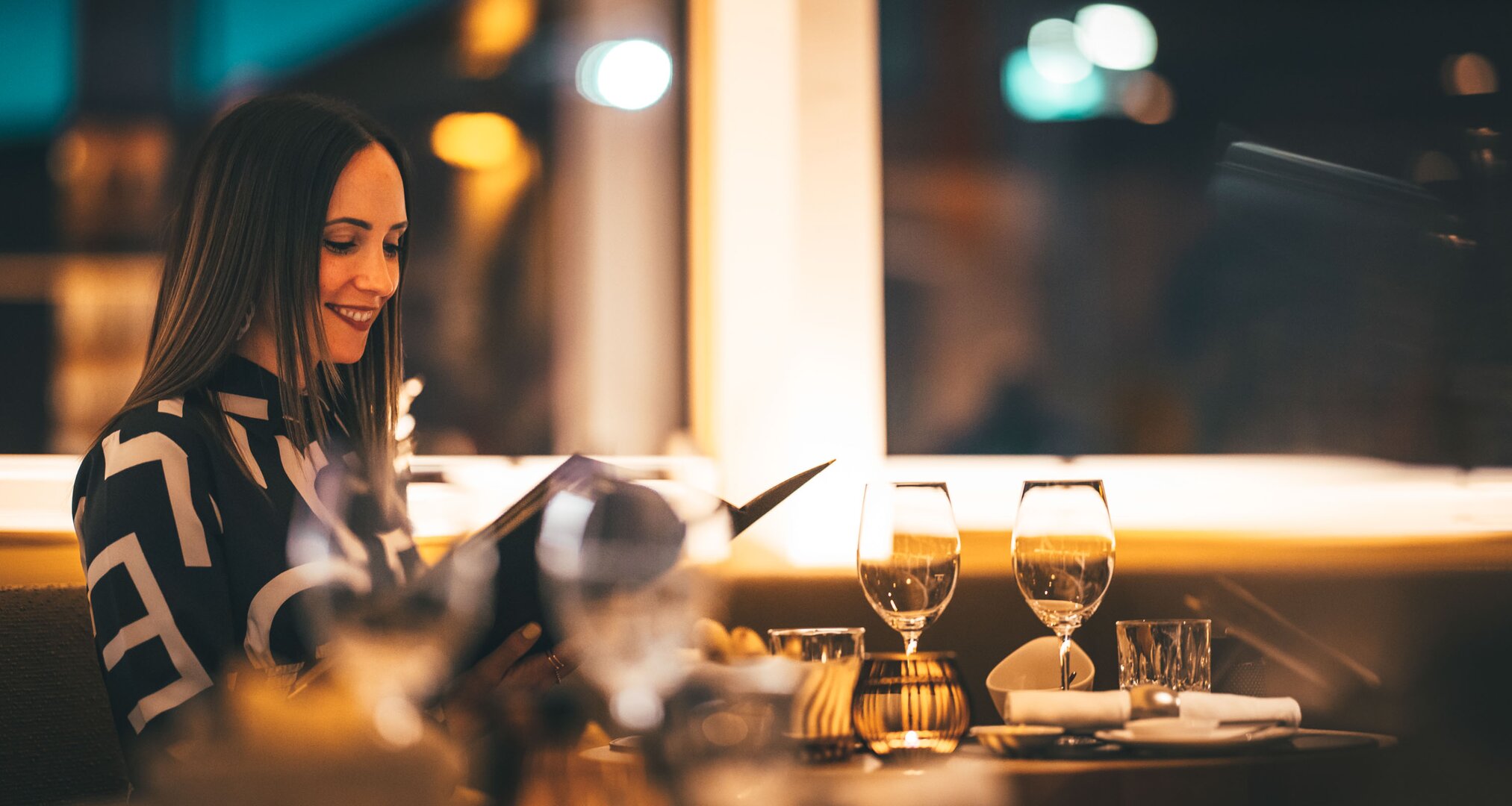 Eine Frau wirft einen Blick in die Speisekarte beim Dinner.