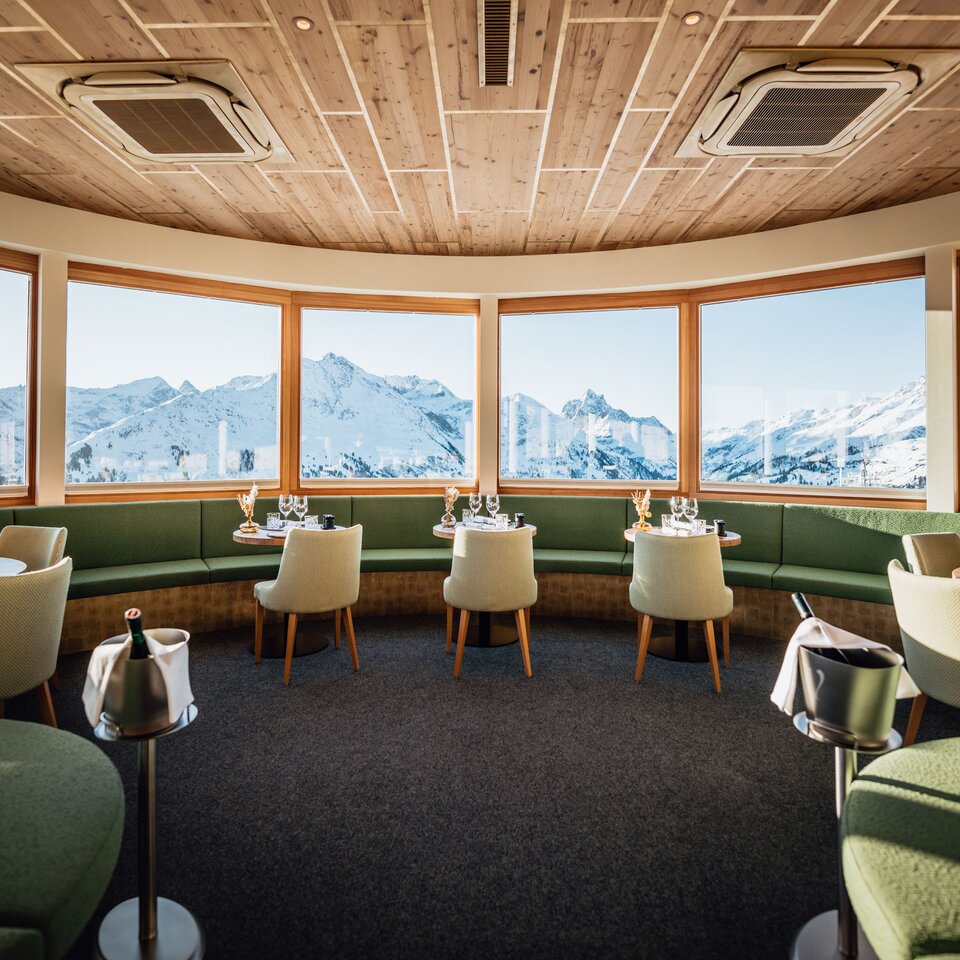 Interior view of a restaurant overlooking snow-covered mountains.