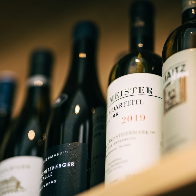 Close-up of wine bottles on a shelf.
