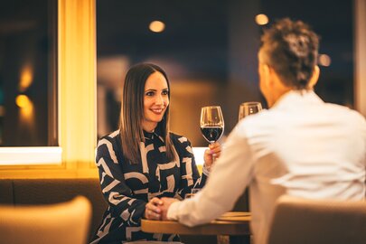 Ein Paar genießt ein Candlelight-Dinner bei Wein im Restaurant.