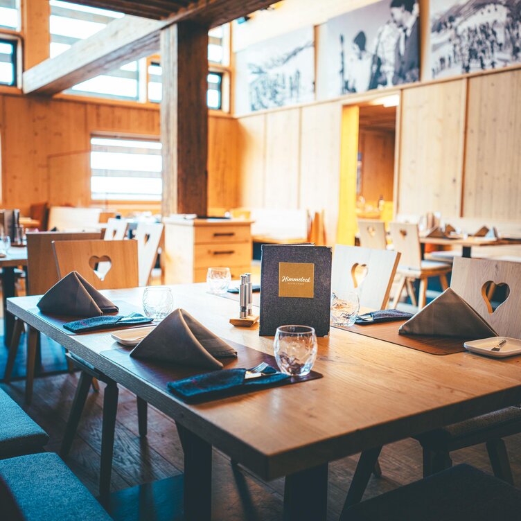 Rustic restaurant with wooden decor and heart-shaped chairs.