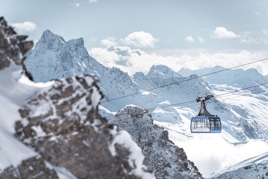 Seilbahn in der Skiregion St. Anton am Arlberg mit verschneiten Bergen im Hintergrund.