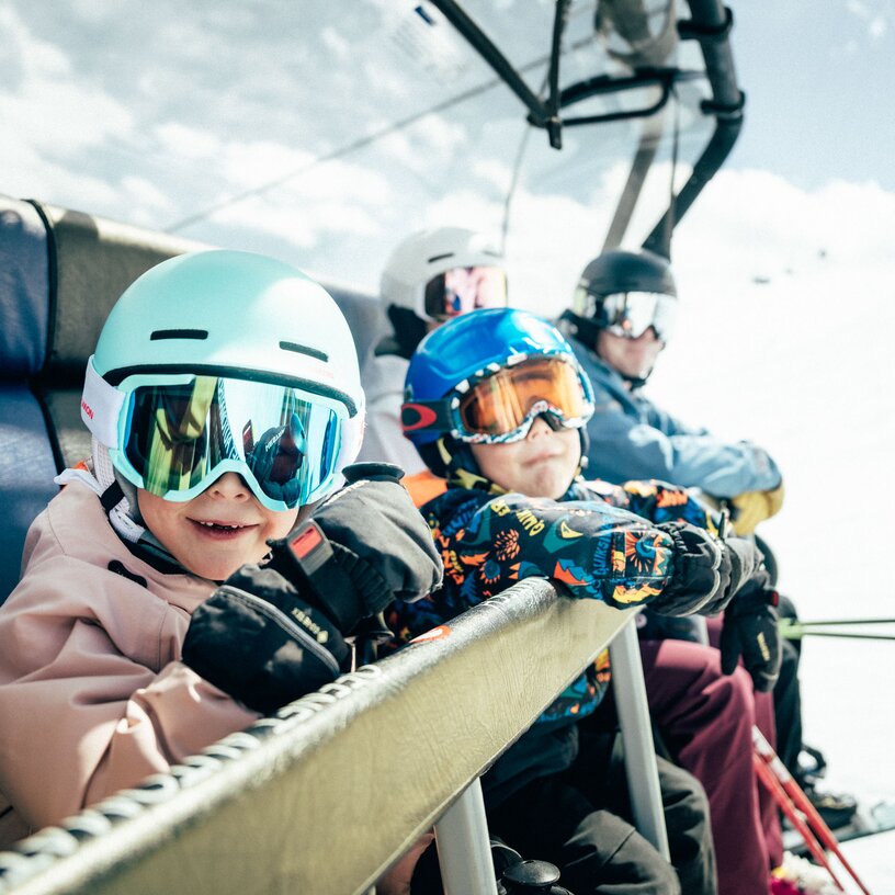 Children with ski gear on a chairlift in St. Anton am Arlberg ski resort.