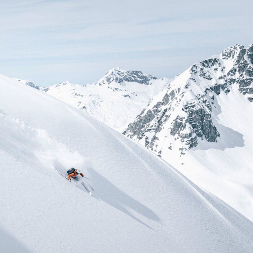 Person skiing on snowy slope in St. Anton am Arlberg ski region.