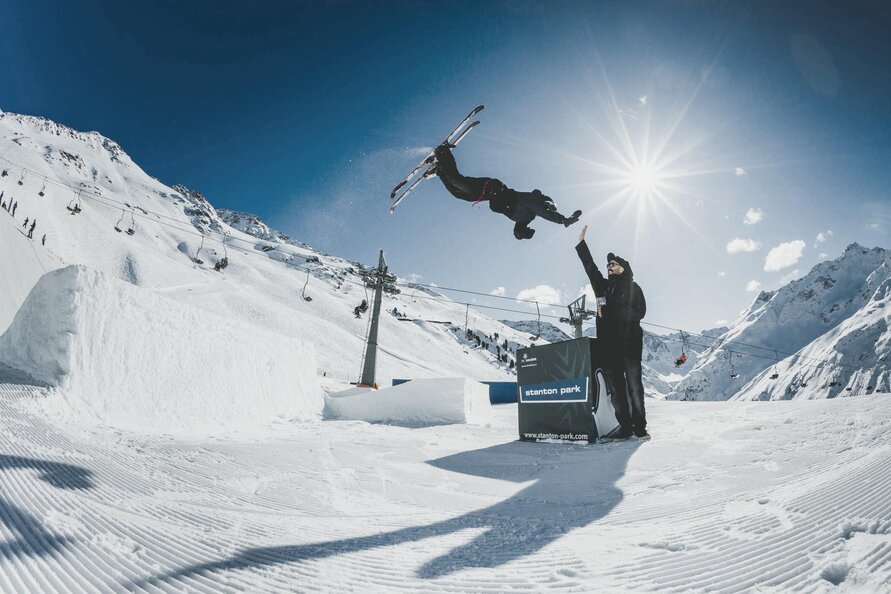 Ein Skifahrer macht einen Sprung im "Stanton Park" - dem Stunt-Park in St. Anton - bei Sonnenschein.