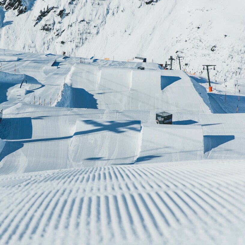 Verschneiter Funpark mit Halfpipes und Sprungschanzen in Stanton Park.