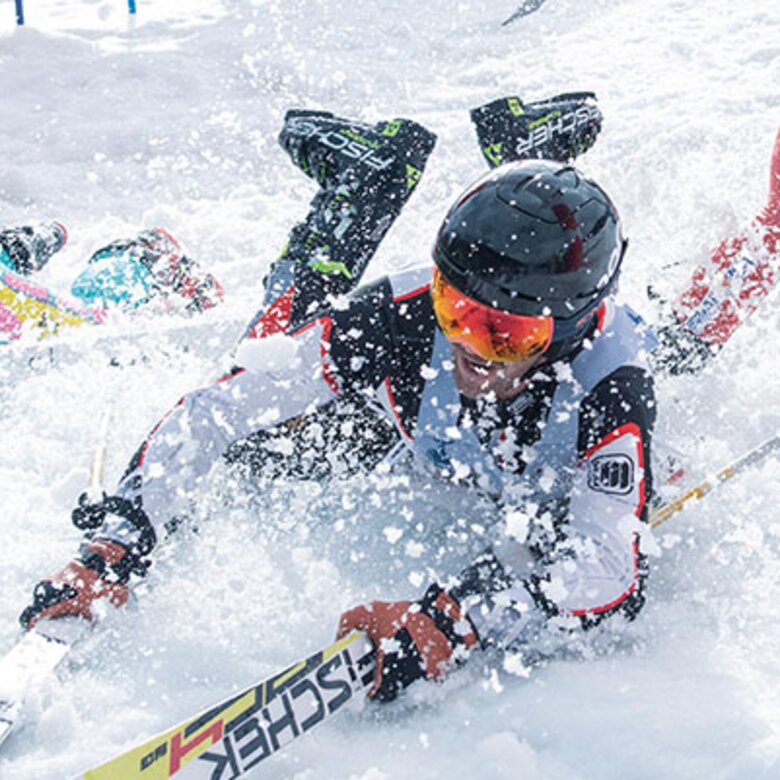 Three skiers fall on the snowy slope during the 'Der Weisse Rausch' ski race.