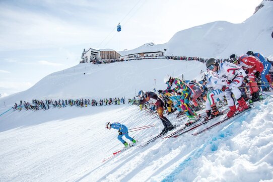 Skiwettbewerbsteilnehmer starten gleichzeitig den Hang hinunter bei "Der Weisse Rausch".