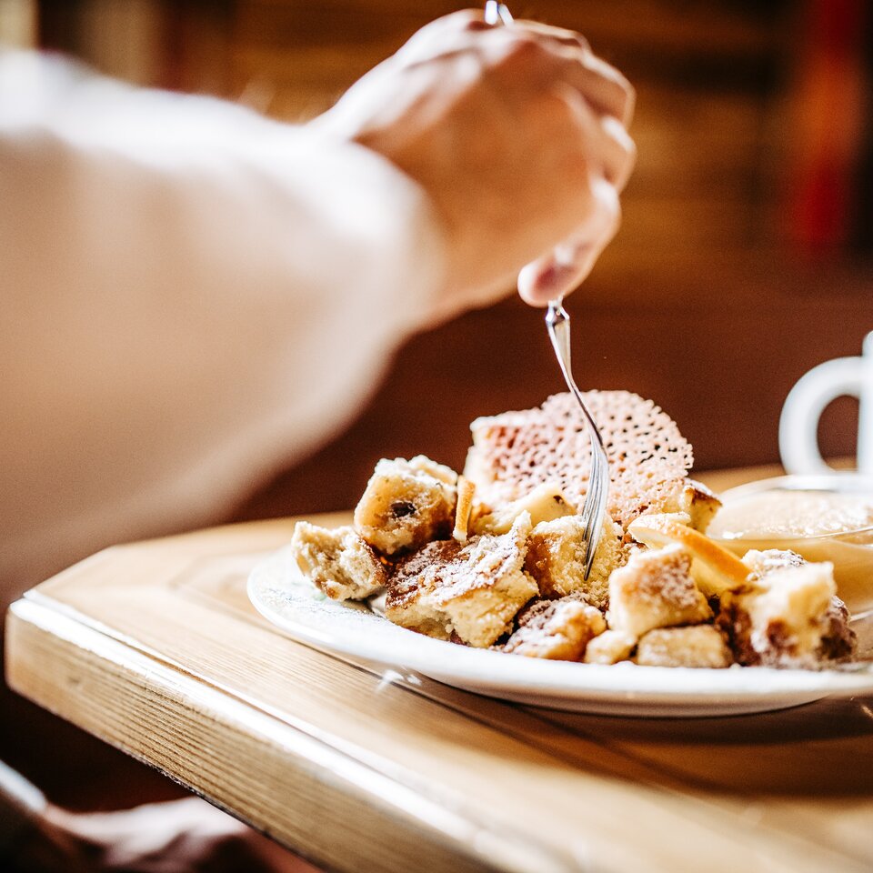 Person genießt Kaiserschmarrn in der Skihütte Hochalp.