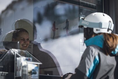Eine Frau kauft ein Skiticket am Ticketschalter.