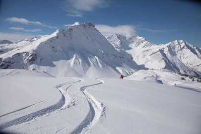 Schneebedeckte Berglandschaft mit frischen Skispuren.