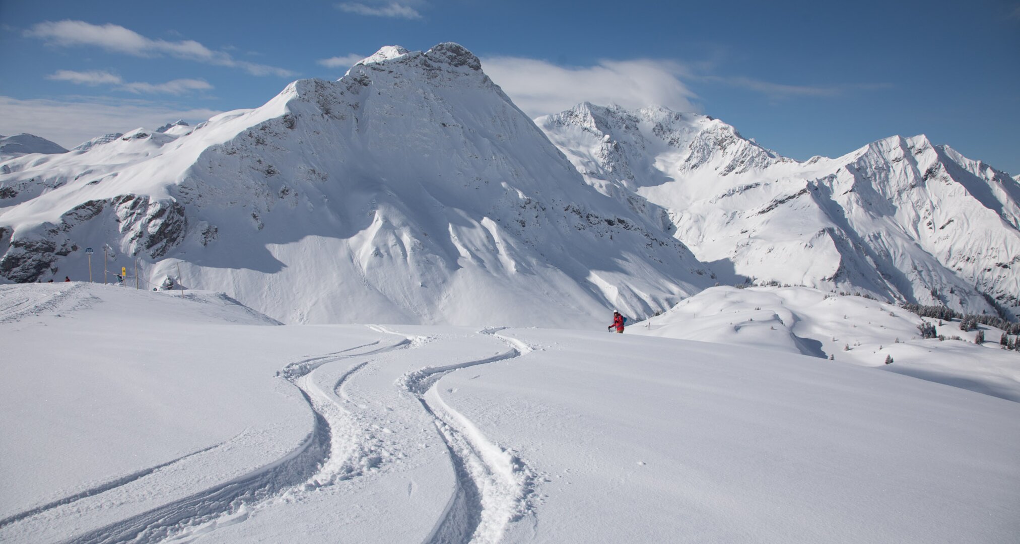 Snow-covered mountain landscape with fresh ski tracks.