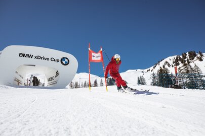 Skifahrer in rotem Anzug auf der Skimovie-Strecke von BMW xDrive Cup.